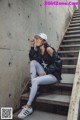 A woman sitting on the steps of a concrete building.