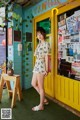 A woman standing in front of a yellow door.