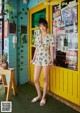 A woman standing in front of a yellow door.