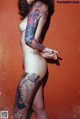 A woman with a tattoo on her body posing for a picture.