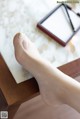 A woman's foot sitting on a table next to a mirror.