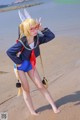 A woman in a sailor outfit posing on a beach.