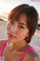 A woman in a pink tank top posing for a picture.