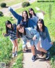 A group of young women posing for a picture in a field.